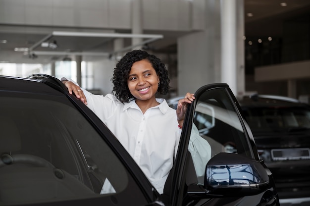 Vrouw geniet van haar financiële onafhankelijkheid terwijl ze een auto koopt