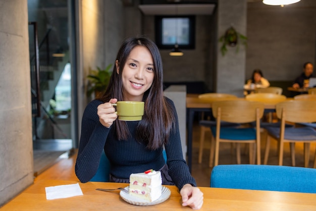 Vrouw geniet van haar koffie in het café