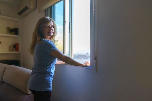 Vrouw geniet van het uitzicht vanuit haar raam