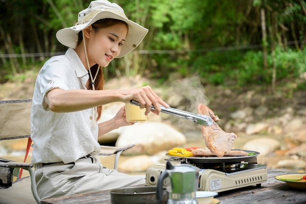 Vrouw geniet van kamperen op de camping, roosterde wat karbonade en maakte een biefstuk