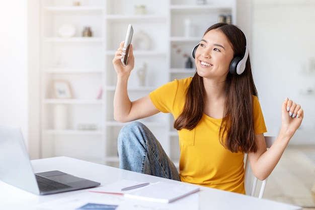 Vrouw geniet van muziek en dansen aan het bureau