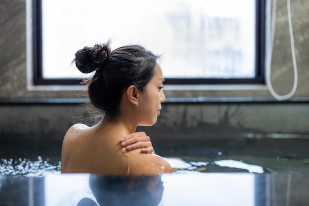 Vrouw geniet van onsen in bad