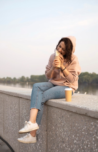 Foto vrouw geniet van wat straatvoedsel