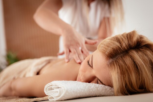 Vrouw genieten tijdens een ontspannen massage in de spa.