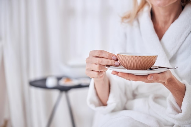 Vrouw genieten van heerlijk kopje thee in kuuroordhotel