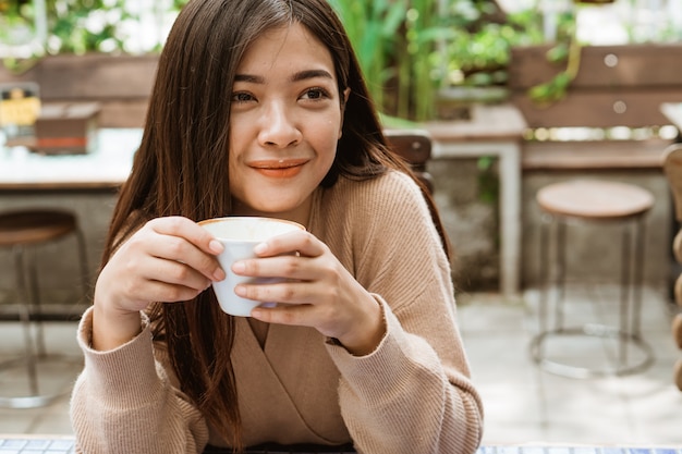 Vrouw genieten van koffie drinken in café