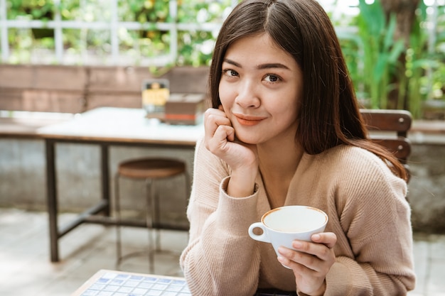 Vrouw genieten van koffie drinken in café