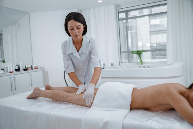 Vrouw genieten van procedure van benen massage in spa salon Beauty concept