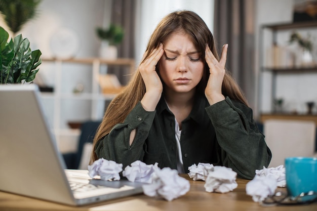 Foto vrouw gestrest over werk op kantoor aan huis en kijk naar iets op het laptopscherm