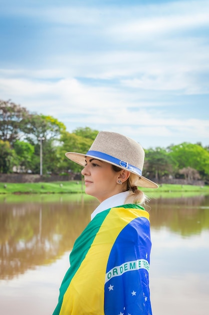 Vrouw gewikkeld in een Braziliaanse vlag met hoed en spijkerbroek Agribusiness woman