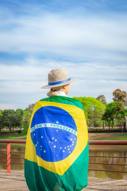 Vrouw gewikkeld in een Braziliaanse vlag met hoed en spijkerbroek Agribusiness woman