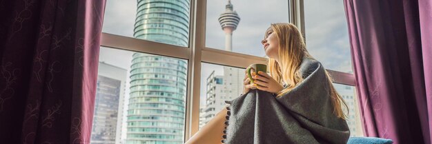 Vrouw gewikkeld in een deken en kijkend naar het lange formaat van de banner van de grote stad