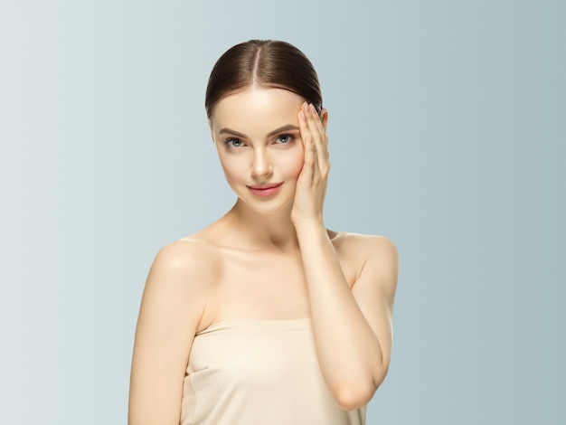 Vrouw gezicht schoonheid hand aanraken van gezonde huid natuurlijke make-up mooie vrouwelijke grijze achtergrond