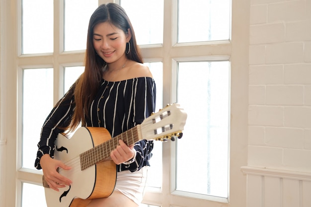 Vrouw gitaar spelen binnenshuis