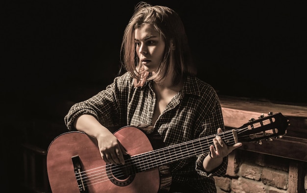 Vrouw gitaar spelen, met een akoestische gitaar in zijn handen. Muziekconcept. Meisje gitarist speelt. Meisje speelt gitaar. Vrouw hipster man zit in een pub.