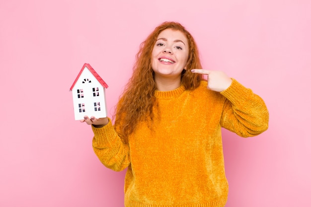 vrouw glimlachend vol vertrouwen wijzend naar eigen brede glimlach, positieve, ontspannen, tevreden houding