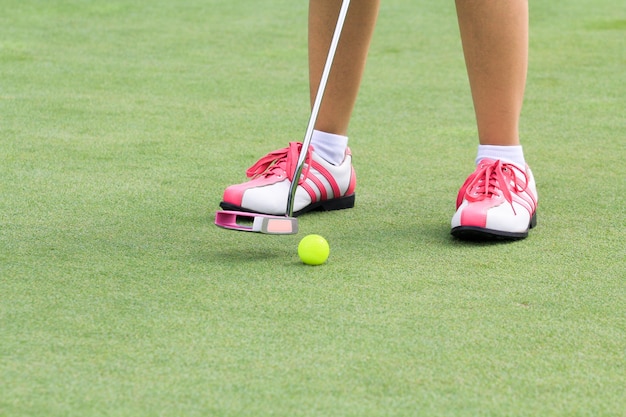 Vrouw golfspeler zetten op de green