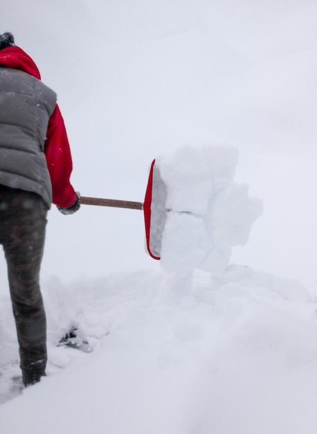 Vrouw gooit sneeuw met een schop