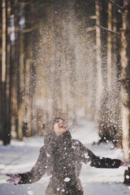 Vrouw gooit terwijl ze met sneeuw speelt