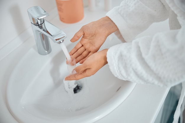 Vrouw haar handen wassen in de gootsteen