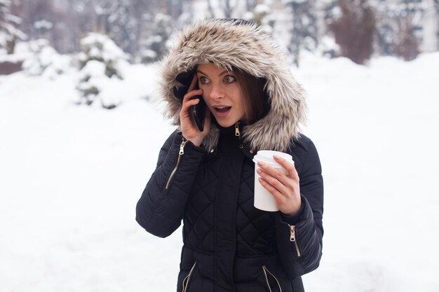Vrouw haar warme drank drinken uit beker. Winter seizoen.