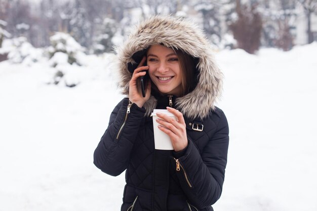 Vrouw haar warme drank drinken uit beker. Winter seizoen.