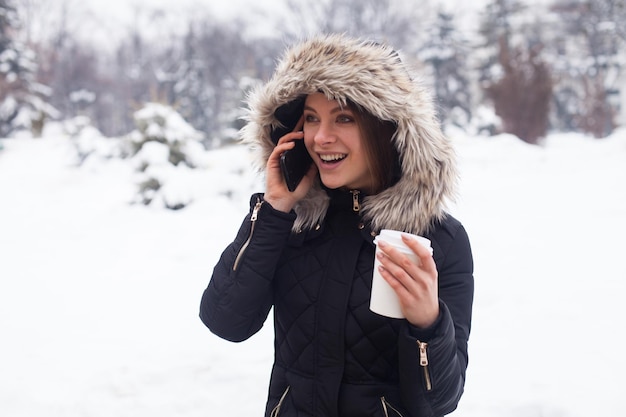 Vrouw haar warme drank drinken uit beker. Winter seizoen.
