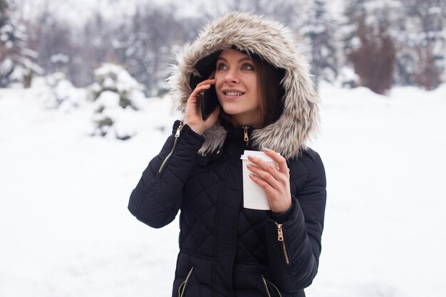 Vrouw haar warme drank drinken uit beker. Winter seizoen.