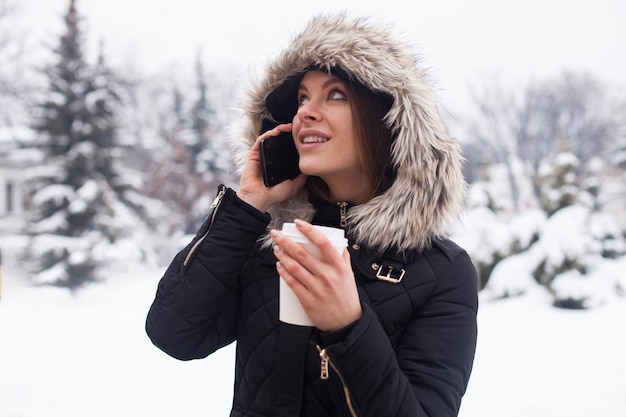 Vrouw haar warme drank drinken uit beker. Winter seizoen.