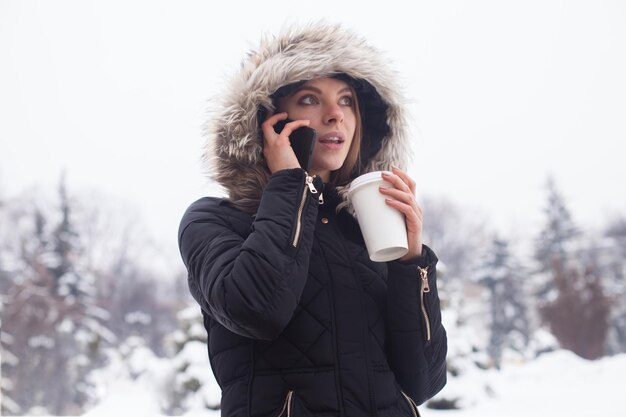 Vrouw haar warme drank drinken uit beker. Winter seizoen.