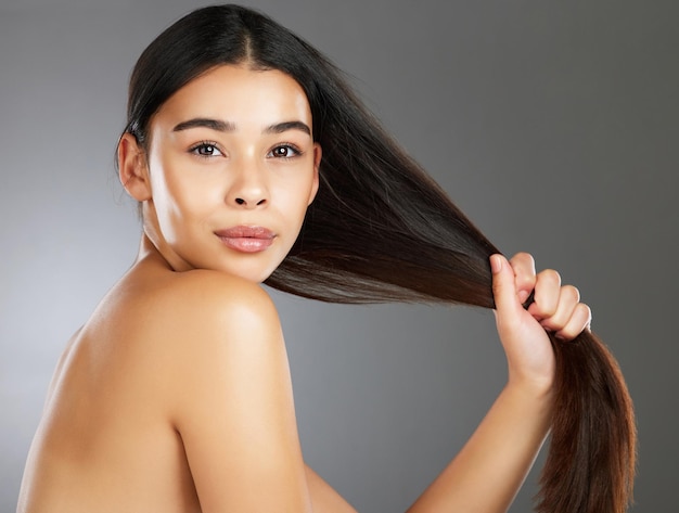 Vrouw haarverzorging en schoonheid in studioportret voor sterke gezonde natuurlijke glans en wellness op achtergrond Model haarglans en cosmetische schoonheid voor gezondheid, esthetiek en zelfvertrouwen op achtergrond