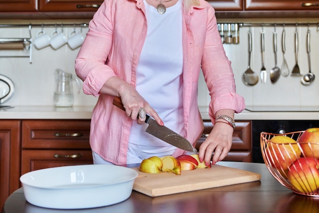 Vrouw hand appels snijden met mes op houten snijplank