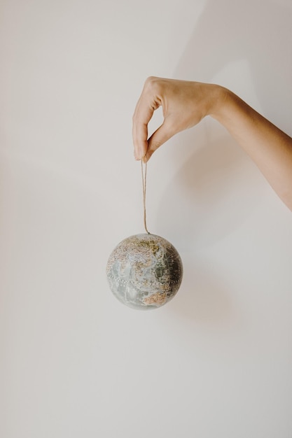 Vrouw hand houden kleine wereldbol op witte achtergrond Wereld planeet aarde model in handen Save the Earth and environment concept