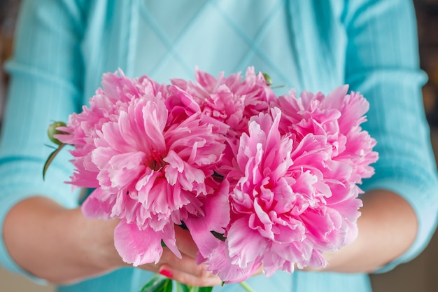 Vrouw hand houden witte pioen bloem.