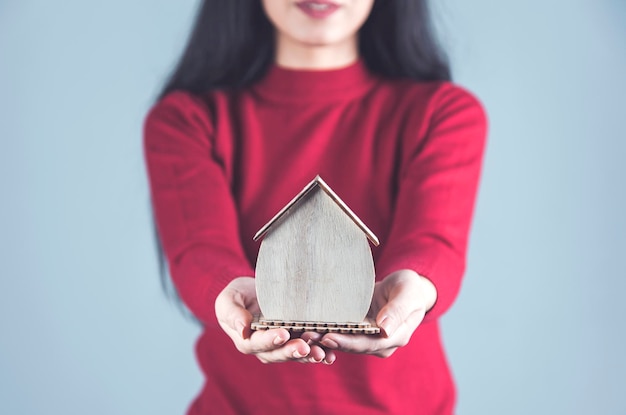 Vrouw hand houten huis model