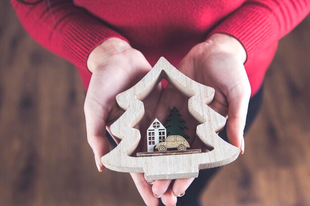 Vrouw hand houten kerstboom