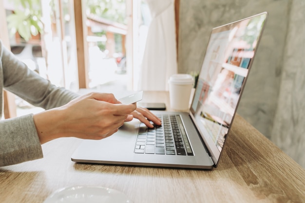 Foto vrouw hand met een creditcard en met behulp van een laptop