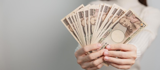 Vrouw hand met Japanse Yen bankbiljetten stapel Duizend Yen geld Japan contant geld Belasting Recessie Economie Inflatie Investeringen financiën en winkelen betalingsconcepten
