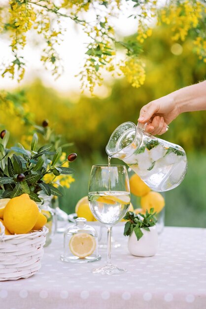 Vrouw hand met mason jar glas mojito en gieten in glas