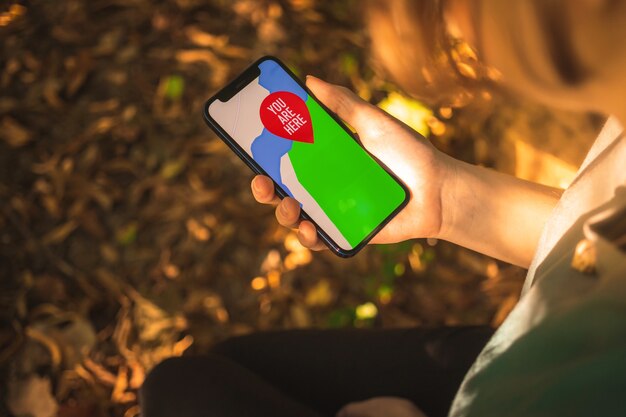 Vrouw hand met mobiele telefoon met de kaart in het bos, buitennavigatie met moderne smartphone, concept van toeristische activiteit foto