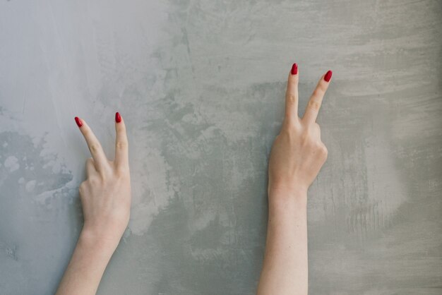 Vrouw hand met rode manicure op een betonnen tafel