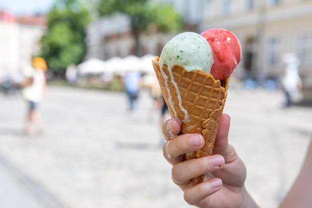 Vrouw hand met smeltend ijs op warme zomerdag