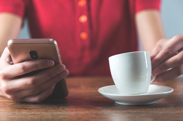 Vrouw hand met telefoon met koffie