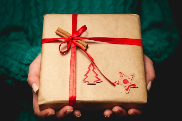 Vrouw hand met verpakt kerstcadeau