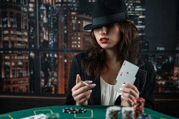 Vrouw hand neemt pokerkaarten aan een ronde pokertafel riskante weddenschappen in poker