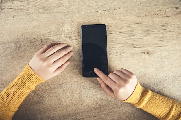 Vrouw hand slimme telefoon op tafel