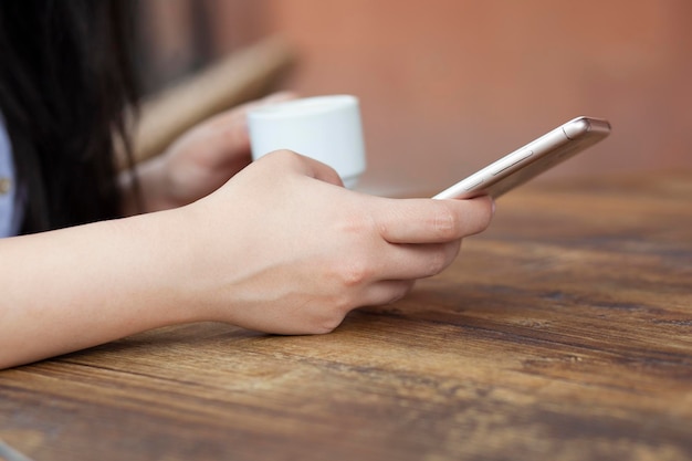 Vrouw hand telefoon en koffie