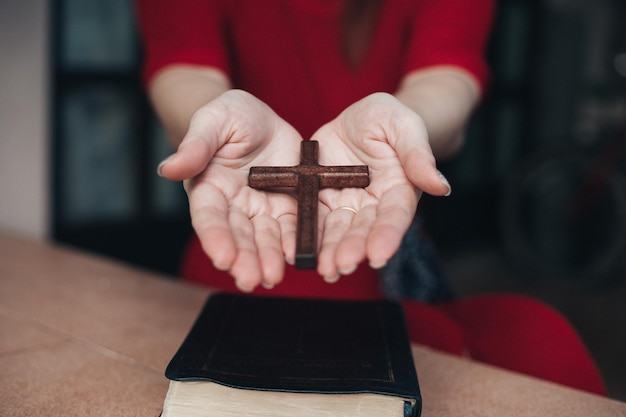 Vrouw handen bidden tot god met houten kruis