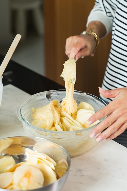 Vrouw handen deeg zetten tijdens het koken van appeltaart