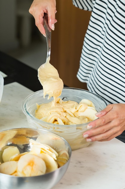 Vrouw handen deeg zetten tijdens het koken van appeltaart